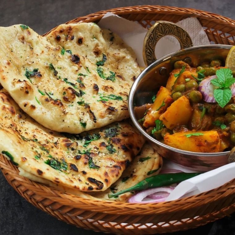 A beautifully presented Vegetable Tandoori dish served with naan and sauce.